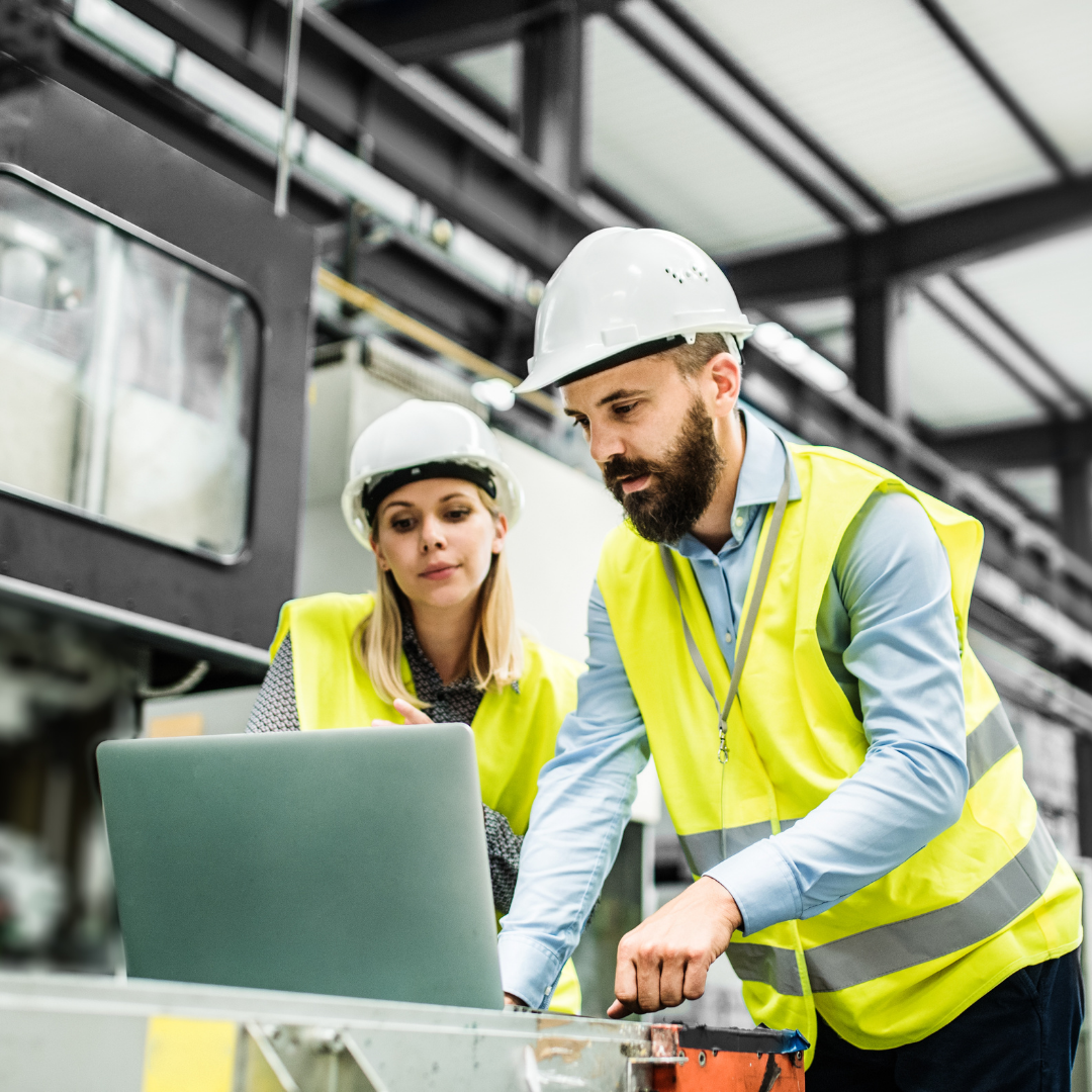 A man in construction gear providing online leadership training to a woman in construction gear